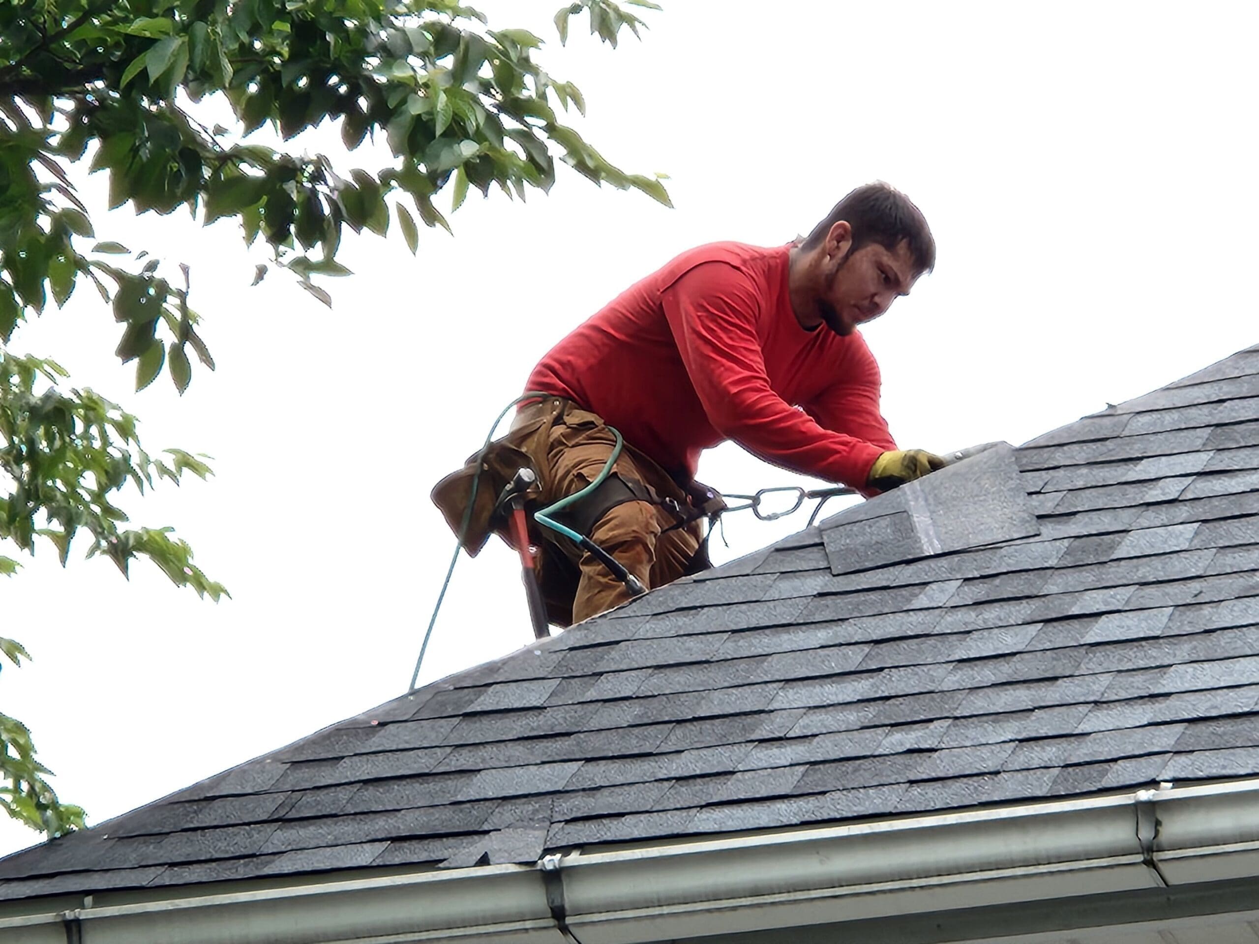 Person repairing a roof leak on a home.